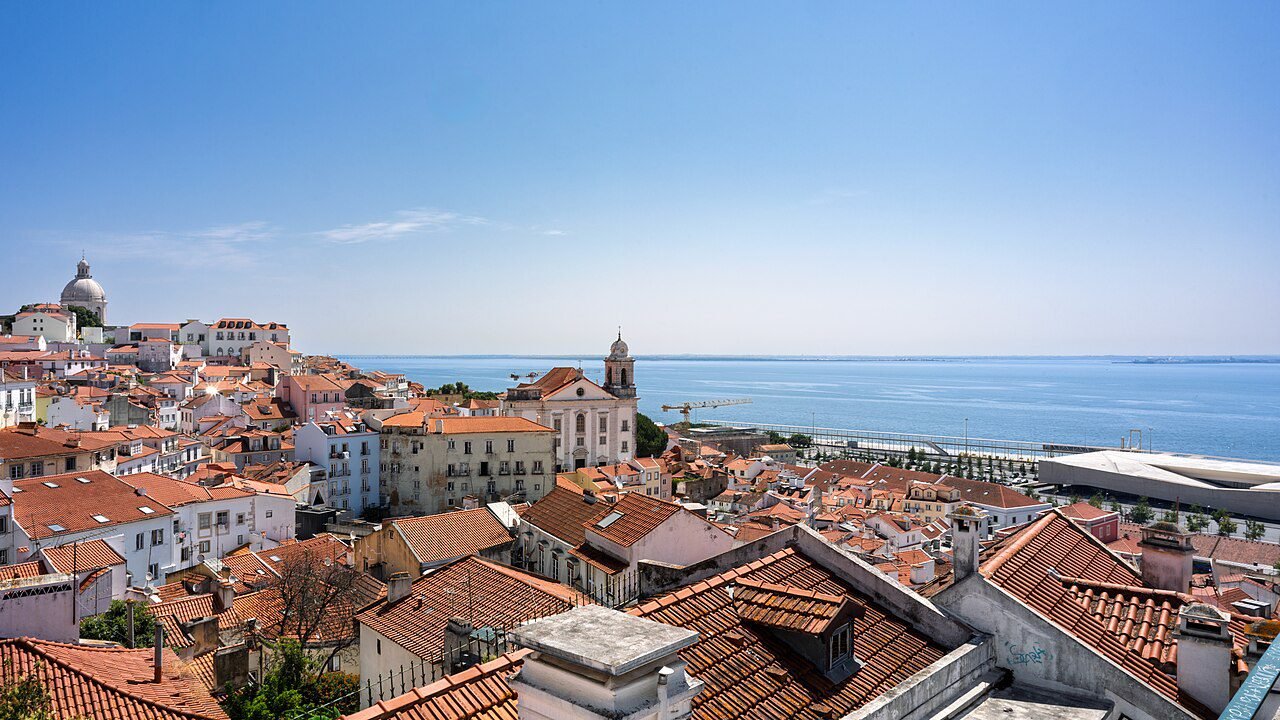 MM2H vs Golden Visa - Alfama rooftops and Tagus River view in Lisbon, Portugal